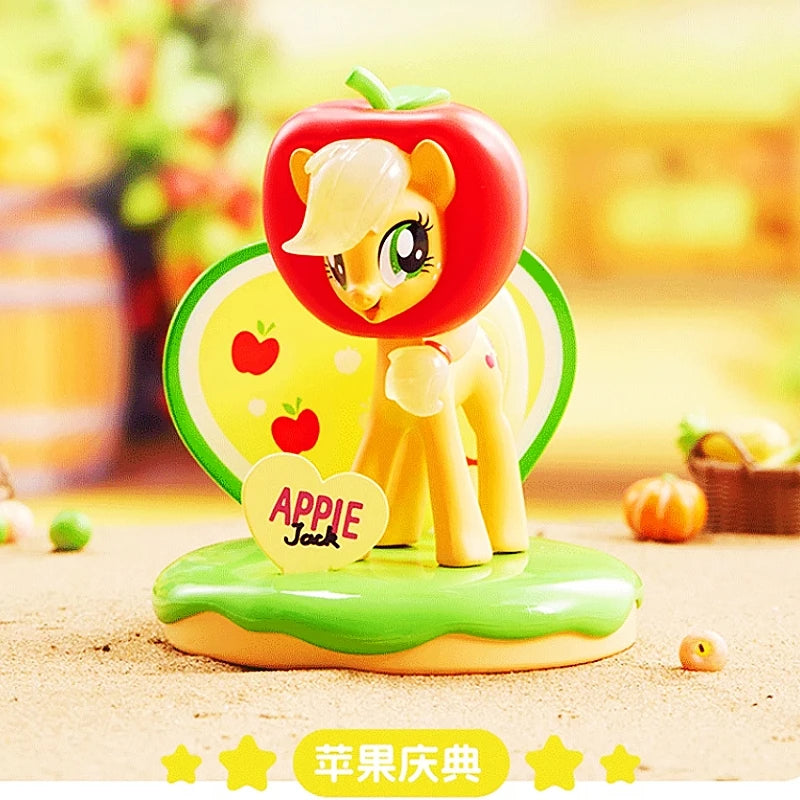 Toy figure of a pony with an apple on top, set against a blurred outdoor background.