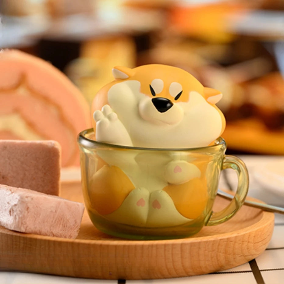 Cute animal-shaped tea infuser in a glass mug on a wooden tray with a blurred background