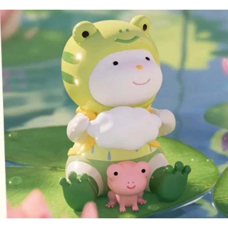 Toy figure of a character in a frog costume sitting on a lily pad with a pink frog toy.