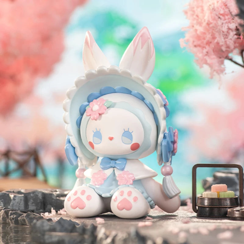 Cute cartoon figurine with bunny ears and a cherry blossom background