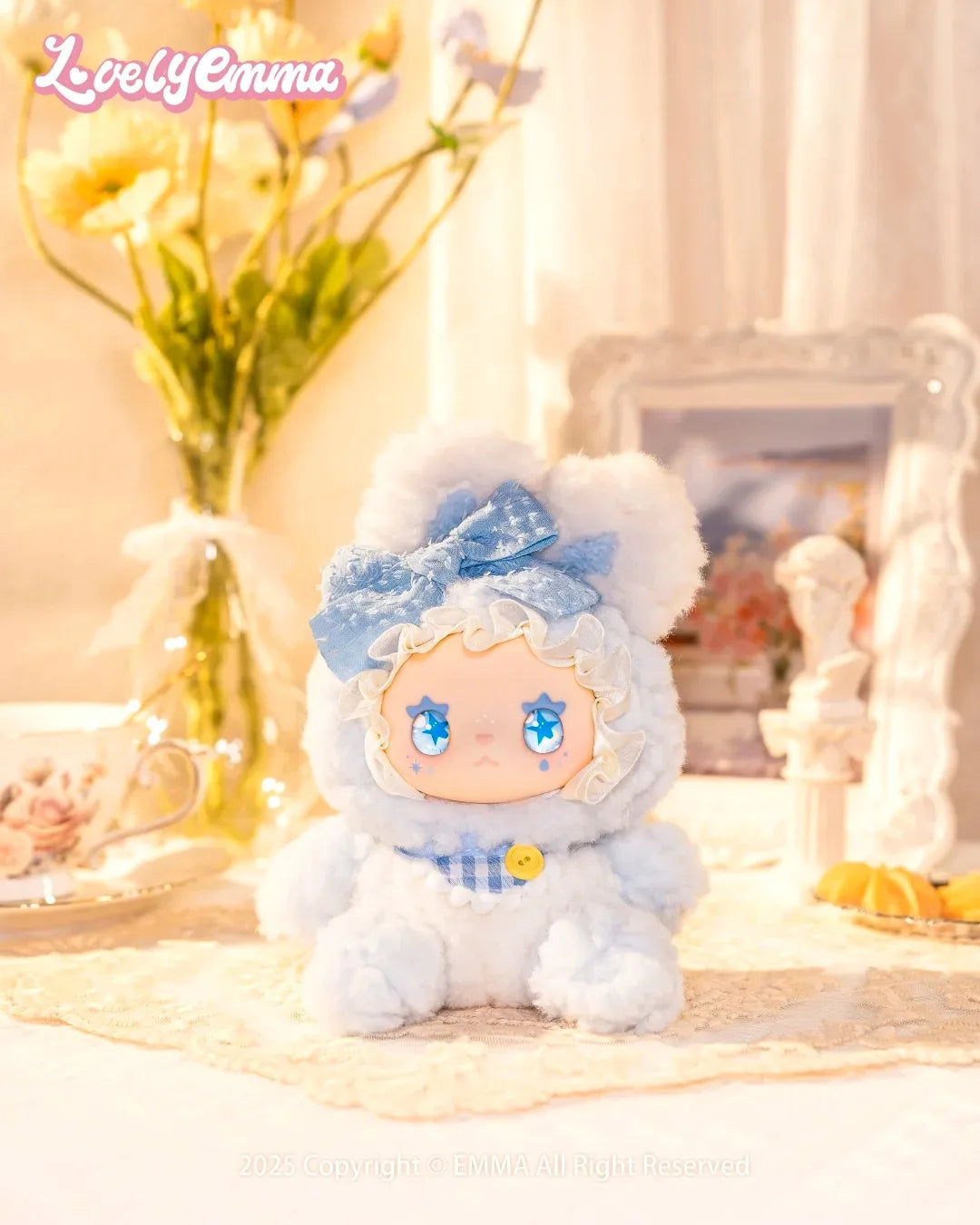 Plush toy with blue accents and a bow on a decorative surface with flowers and a mirror in the background.