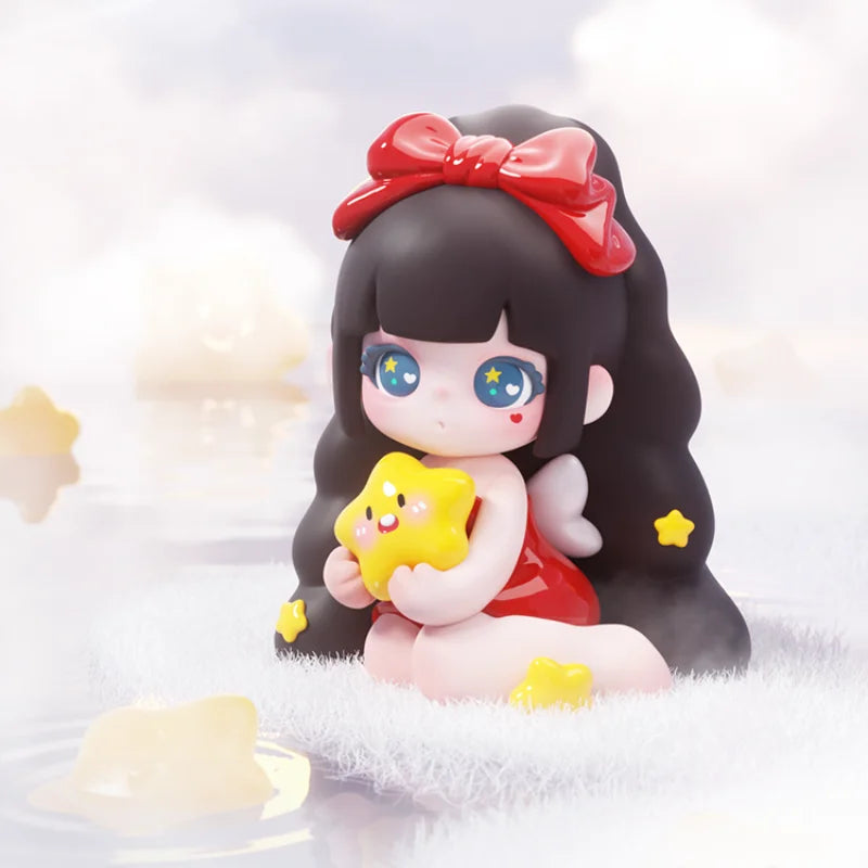 Toy figure with black hair, red bow, and star-shaped object on a white background