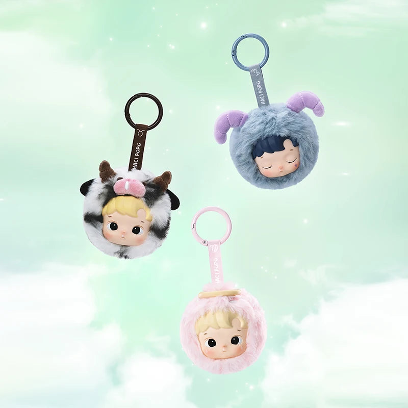 Three plush keychains with character faces on a light green background