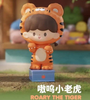 Toy figure of a tiger with a child-like face, standing on a grassy area with a blurred background.