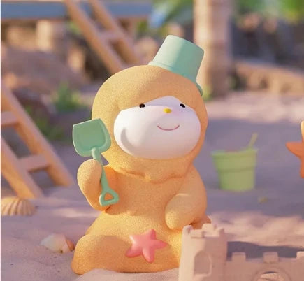 Toy figure of a character in a beach outfit with sand toys on a sandy background