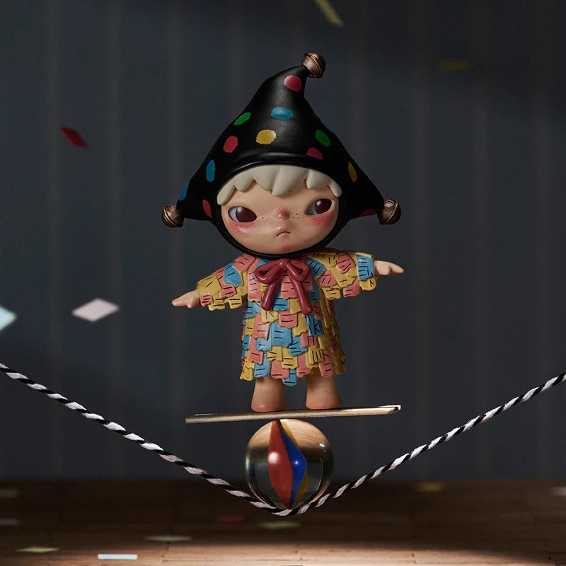 Colorful clown figurine balancing on a ball with a dark background