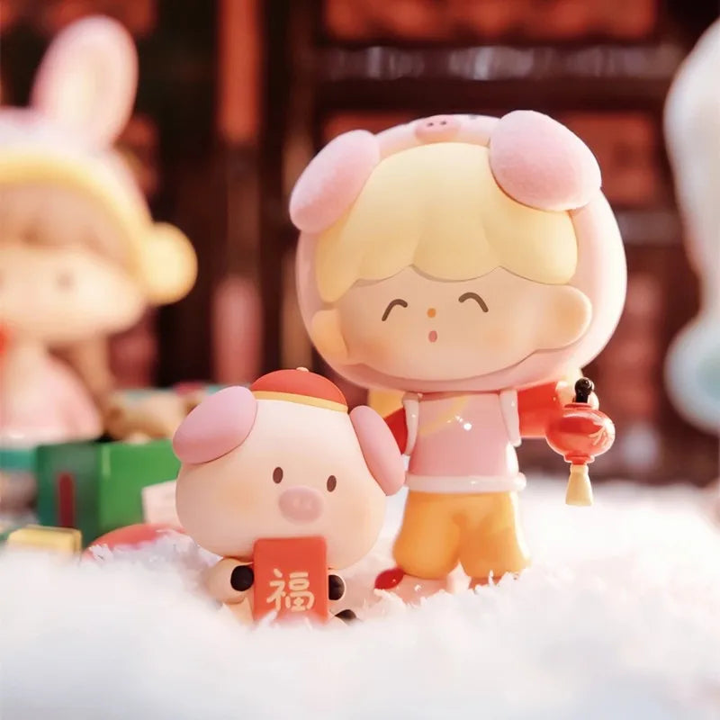 Two cartoon-style figurines with pink hair and traditional outfits on a white surface.