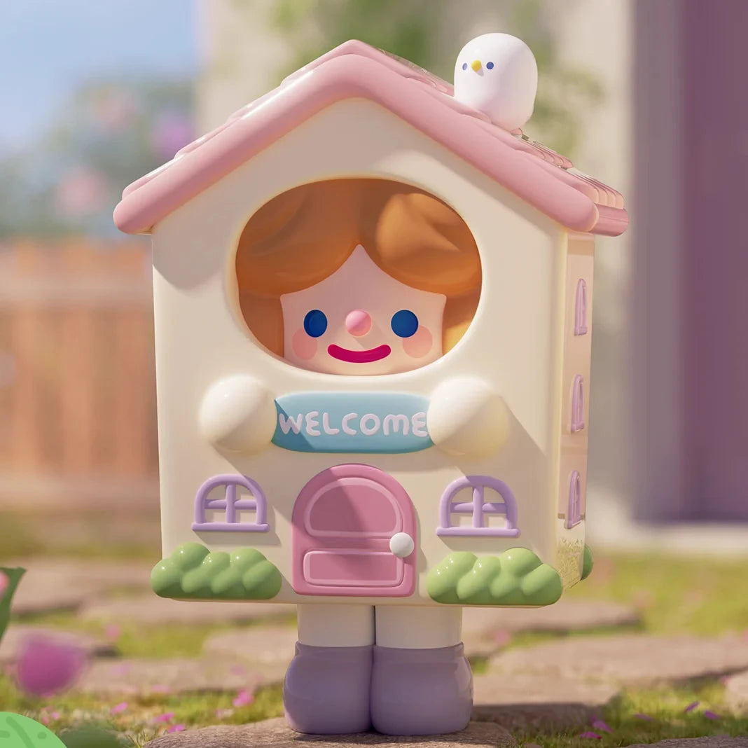 Toy house with a character inside, resembling a girl, in a garden setting.
