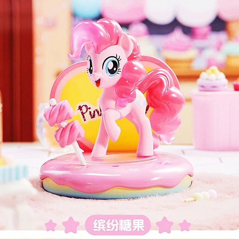 Pink pony figurine on a rainbow platform with a blurred colorful background
