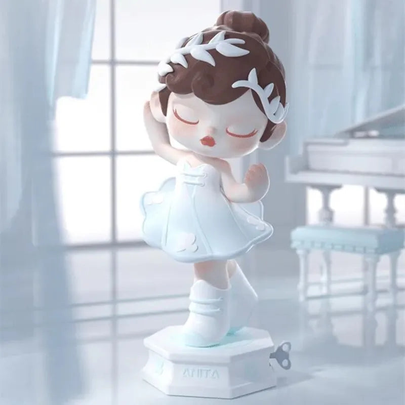 Decorative figurine of a ballerina in a white dress with brown hair, standing on a light surface.