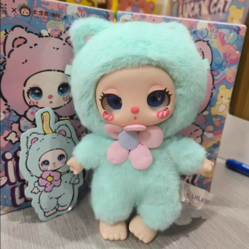 Toy figure in a light blue outfit with a pink flower, standing in front of colorful packaging.