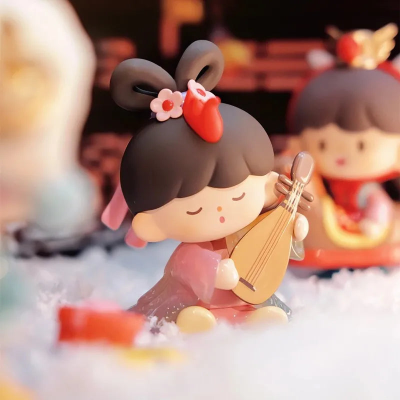 Toy figure of a girl with a traditional hairstyle holding a musical instrument, with a blurred background.