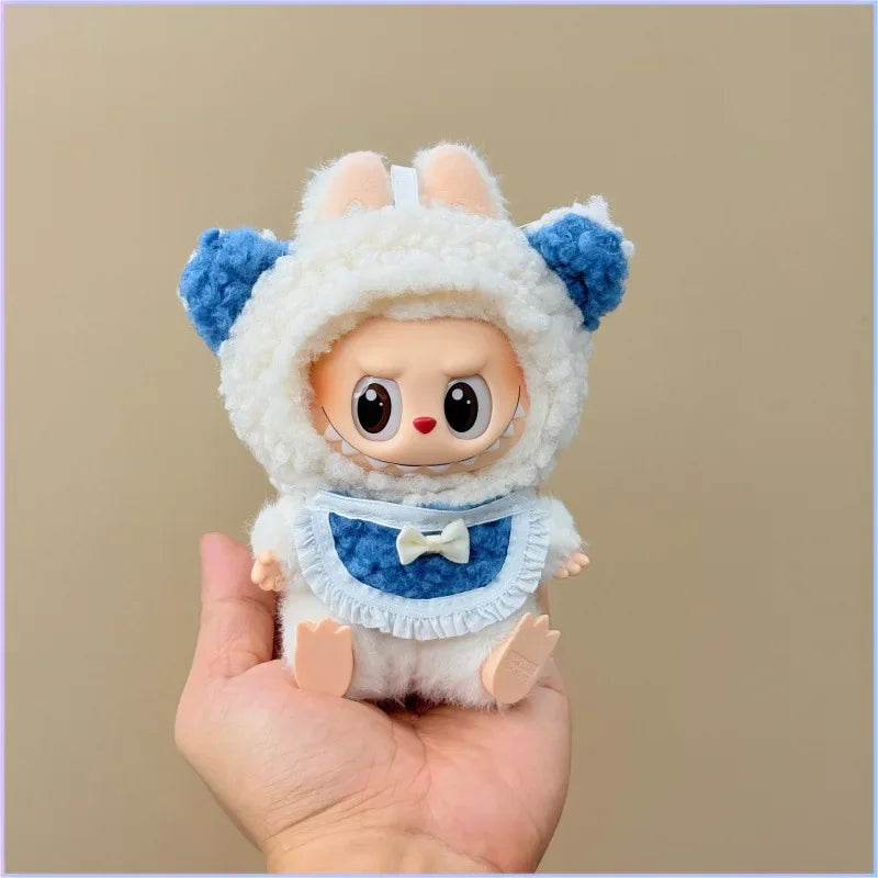 Small plush toy with a white outfit and blue accents held in a hand against a beige background