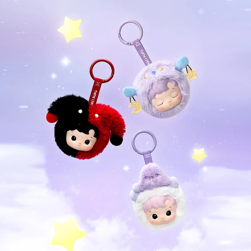Three plush keychains with cartoon characters on a purple background with stars.