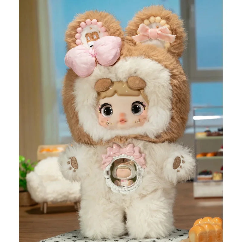 Stuffed animal toy with a face, wearing a brown and white outfit with pink bows, in a room setting.
