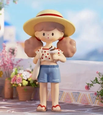 Toy figure of a girl with a straw hat and sunglasses, standing outdoors with flowers and a blurred background.
