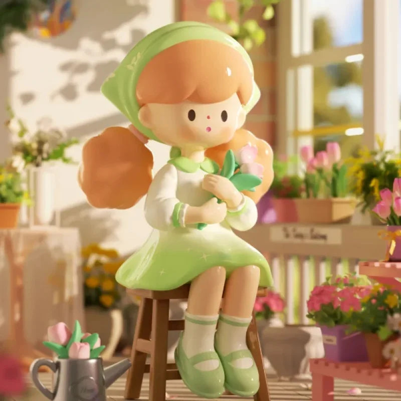 Plush toy of a girl in a green dress sitting on a stool with flowers in a garden setting.