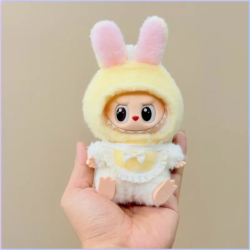Plush toy with bunny ears held in a hand against a beige background
