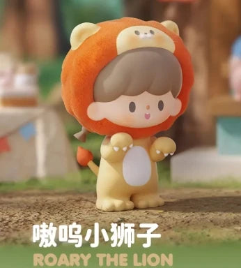 Toy figure of a lion with a child-like face, wearing an orange hood, on a blurred outdoor background.