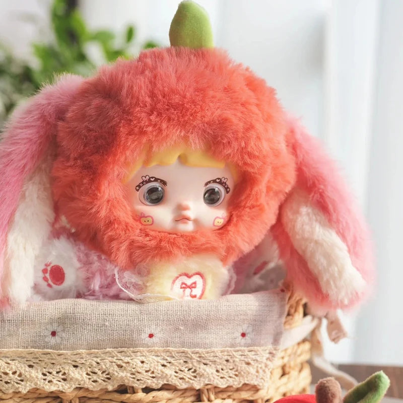 Toy figure with pink fluffy hair and bunny ears sitting in a basket.