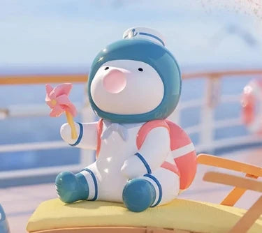 Cartoon character with a blue helmet and pink cheeks sitting on a yellow surface with a blurred background