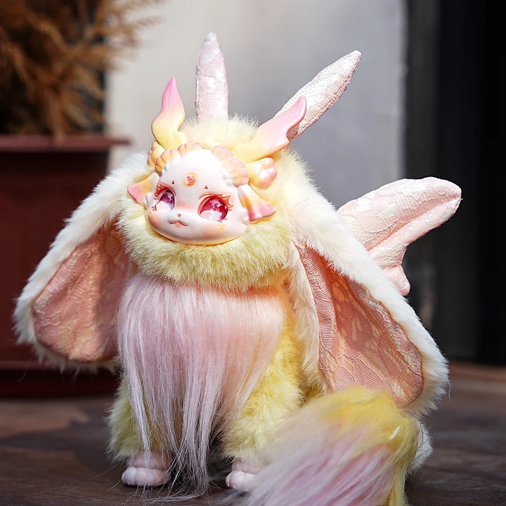 Plush toy with unicorn and bat design on a wooden surface