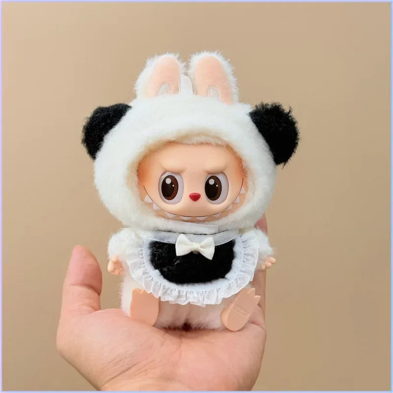 Toy figure wearing a panda costume held in a hand against a beige background