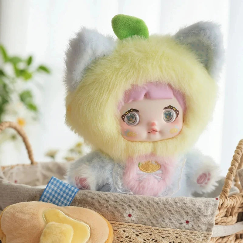 Stuffed animal with a fluffy yellow hood and cat ears, sitting in a basket.