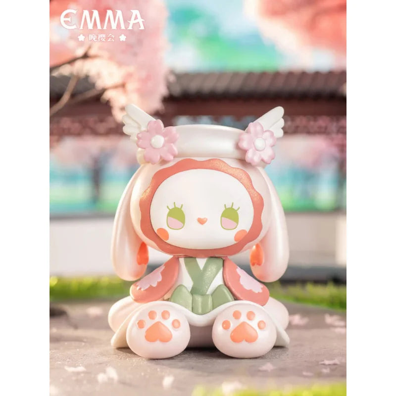 Cute figurine with angel wings in a cherry blossom garden
