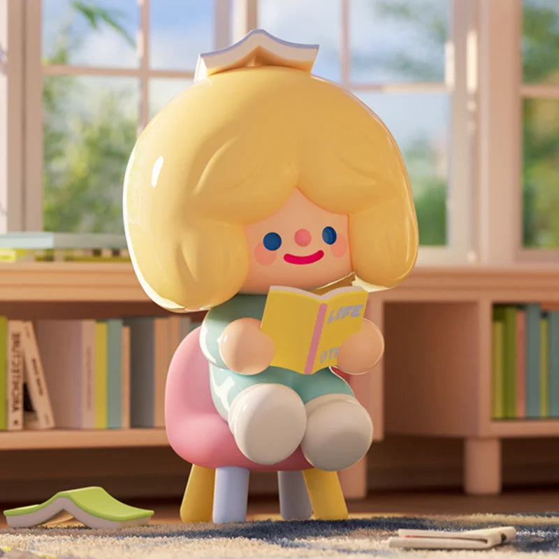 Toy figure with blonde hair and a book, sitting on a rug with a blurred bookshelf in the background.