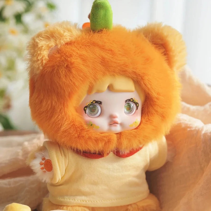 Toy figure with orange furry hood and white face, wearing a white outfit with paw print design.
