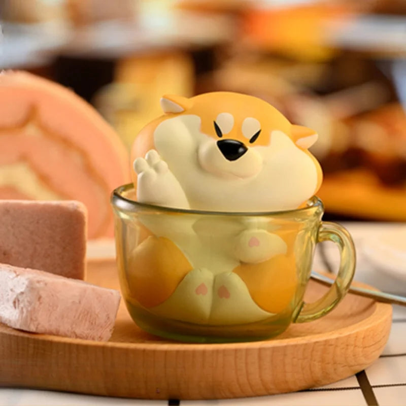 Glass mug with a cute animal-shaped tea infuser on a wooden tray.