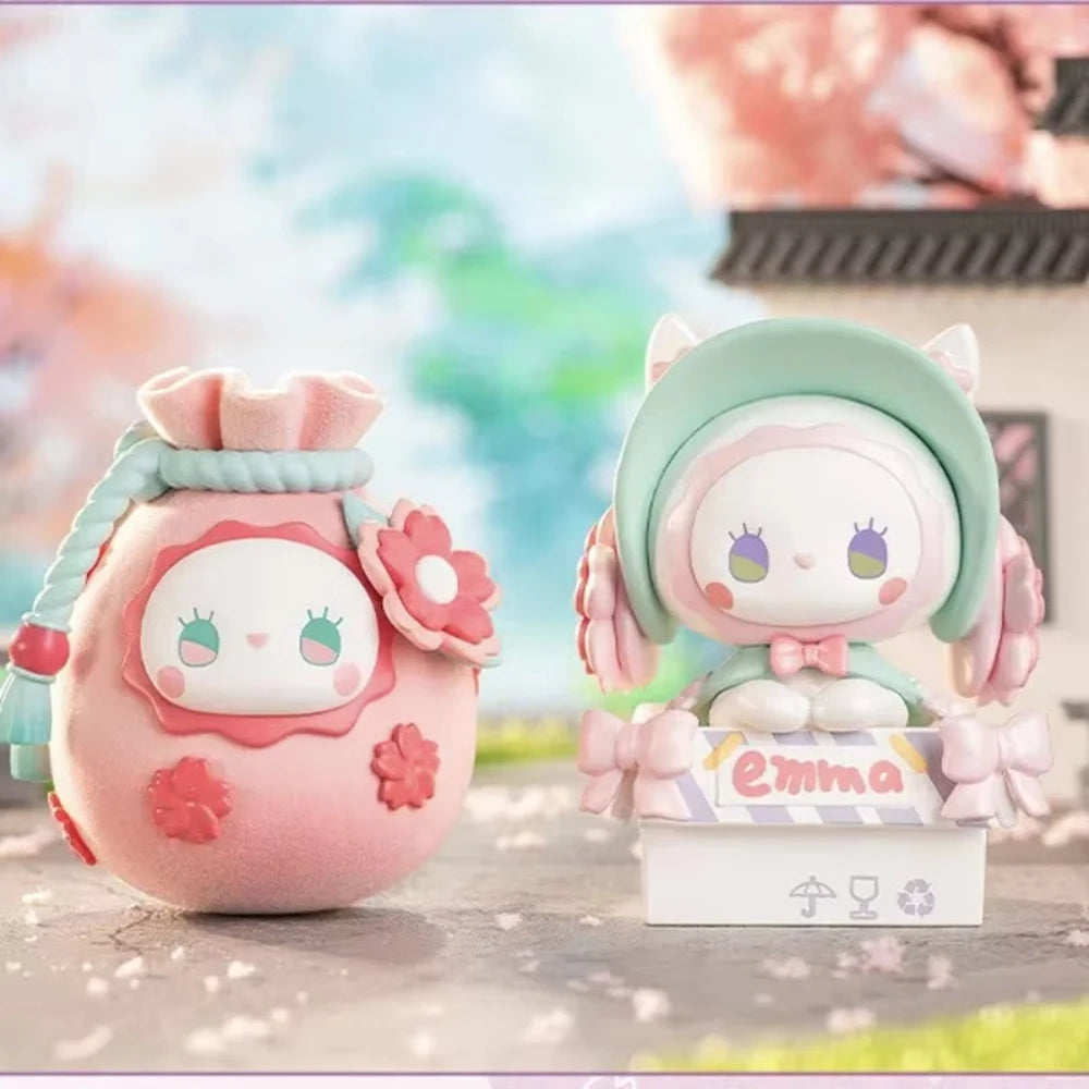 Two cute plush toys with floral designs on a blurred outdoor background