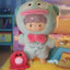 Plush toy character in a colorful room with a pink plush toy.