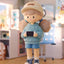 Toy figure of a character wearing a cap and holding a game controller in a room setting.