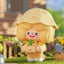 Toy figure with a yellow hat and bear plushie in a garden setting