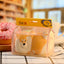 Cute dog-shaped container in clear packaging with a yellow label on a blurred background