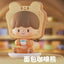 Toy figure of a bear with bread-shaped head in a blurred indoor setting