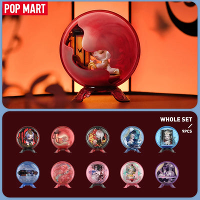 Decorative figurines in transparent red, pink, and blue spheres with a Pop Mart logo.