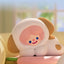 Plush toy shaped like a cartoon character with a smiling face on a blurred background