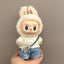Toy figure of a character in a bunny costume held by a hand against a plain background