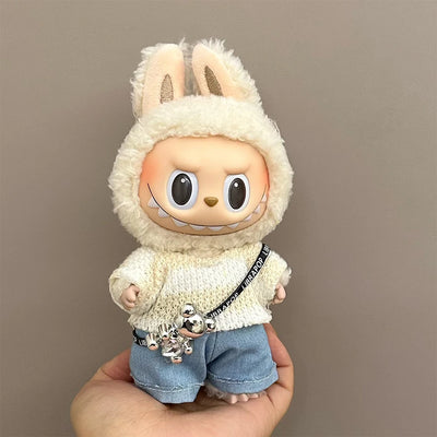 Toy figure of a character in a bunny costume held by a hand against a plain background