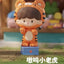 Toy figure of a tiger with a child-like face, standing on a grassy area with a blurred background.
