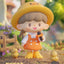 Animated character with a yellow hat and orange outfit holding a microphone, with small yellow creatures around, set against a blurred natural background.