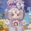 Cute plush toy with fluffy purple hair and bow accessories on a blurred indoor background