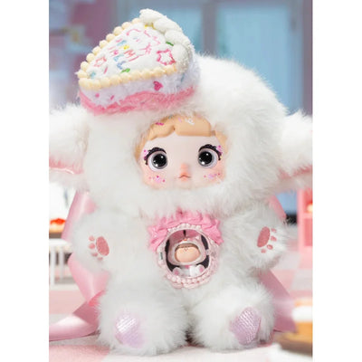 Plush toy with a heart-shaped cookie hat and pink bow on a blurred background