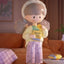 Animated character holding a bag of chips in a living room setting