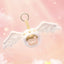 Plush angel keychain with wings on a pink background