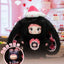 Plush toy with black fur and pink accents in a decorative setting