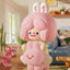 Pink cartoon character plush toy in a room with furniture and decor